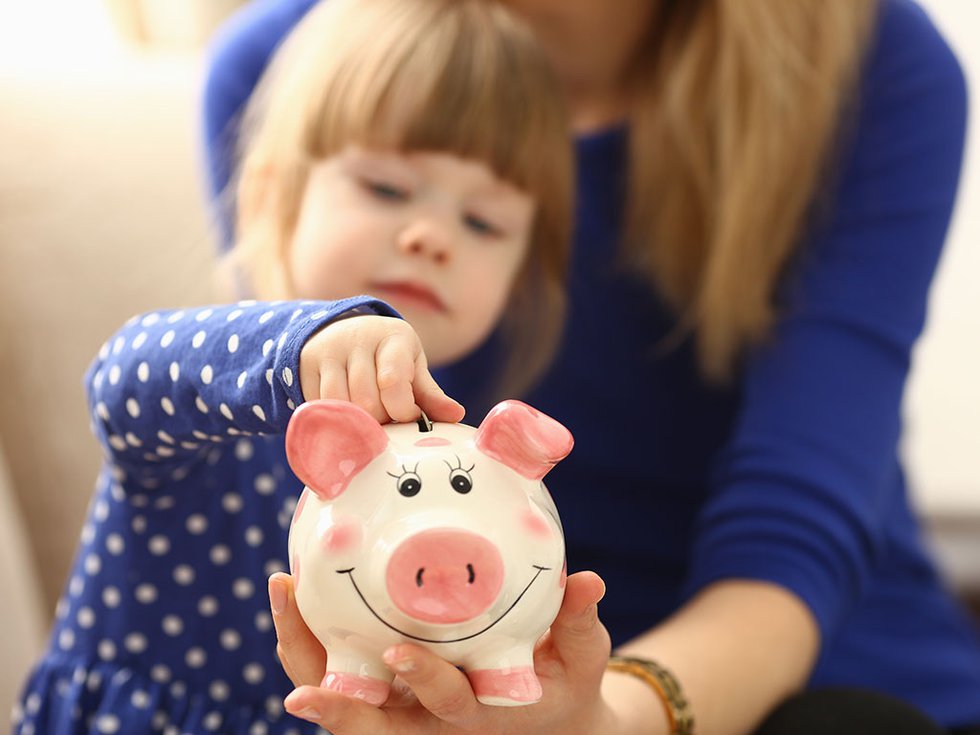 Child Putting Money in Piggy Bank.jpg
